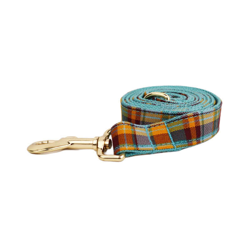 Laisse pour chien en tissu plaid orange et turquoise avec attache dorée, idéale pour promenades stylées.