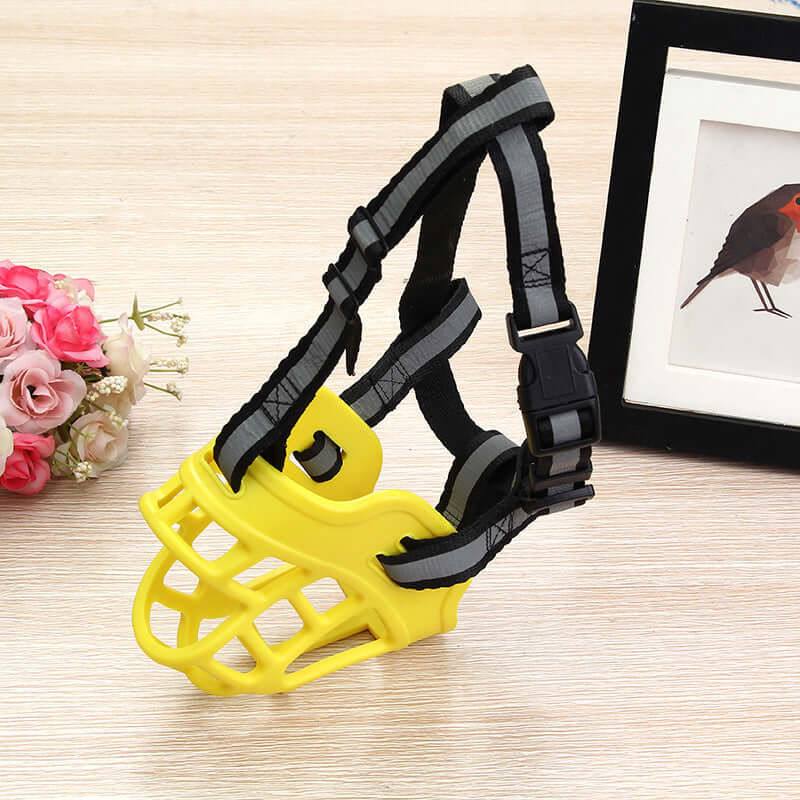 Masque en silicone pour chien en jaune, conçu pour limiter les aboiements et les morsures, avec sangles ajustables.
