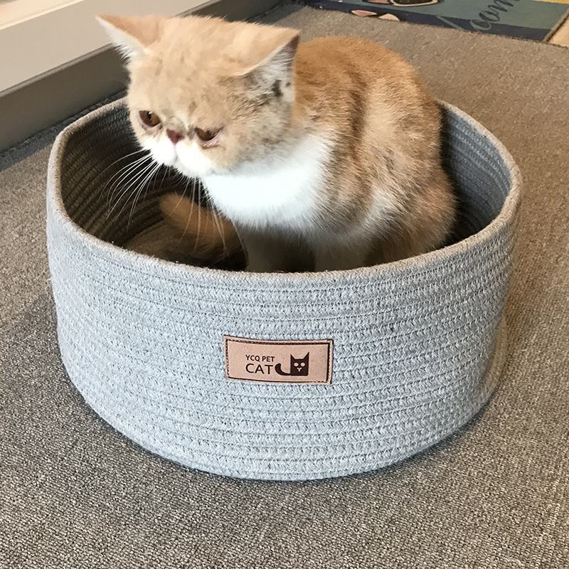 Chat assis dans une litière en corde de coton fait main, douce et respectueuse de l'environnement.
