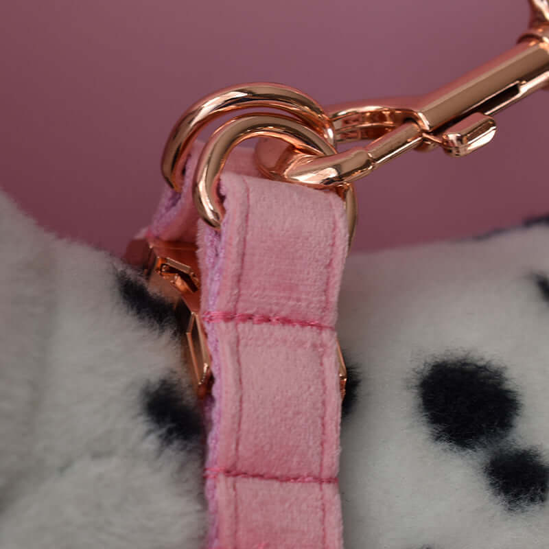 Close-up of a pink dog harness clip featuring a golden attachment, showcasing the soft flannel fabric.