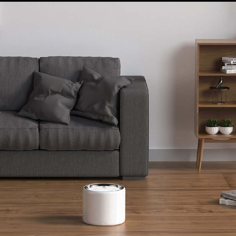Modern living room with a gray couch, pillows, and a stylish white side table.