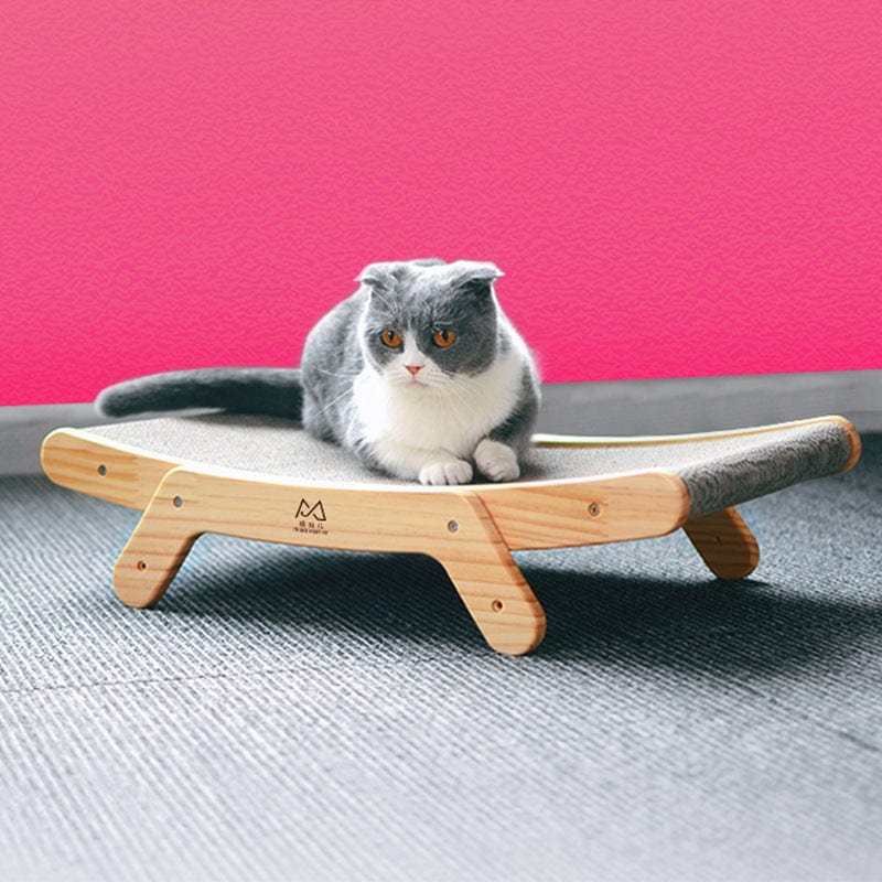 Chat gris assis sur un lit grattage vertical en papier ondulé, design élégant et confortable.