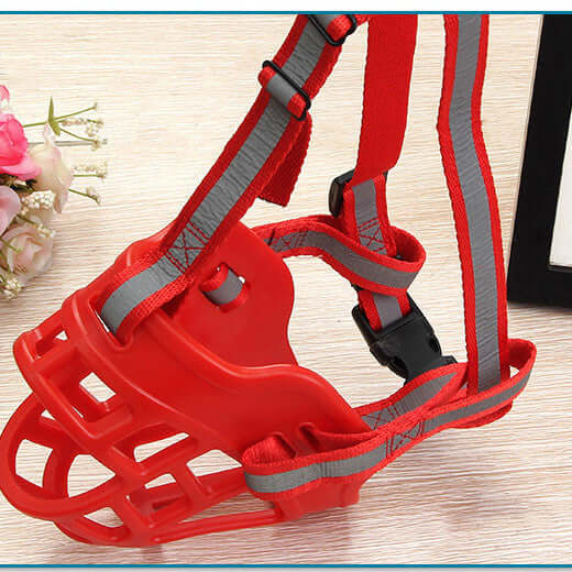 Masque en silicone rouge pour chien, conçu pour limiter les aboiements et les morsures.