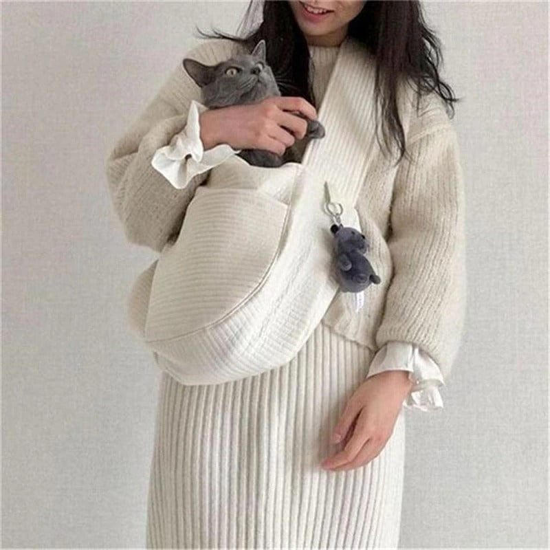 Femme portant un sac de transport pour chat en coton blanc, offrant confort et style.