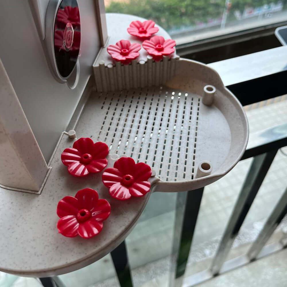 Détails du distributeur intelligent d'oiseaux avec fleurs rouges décoratives en plastique.