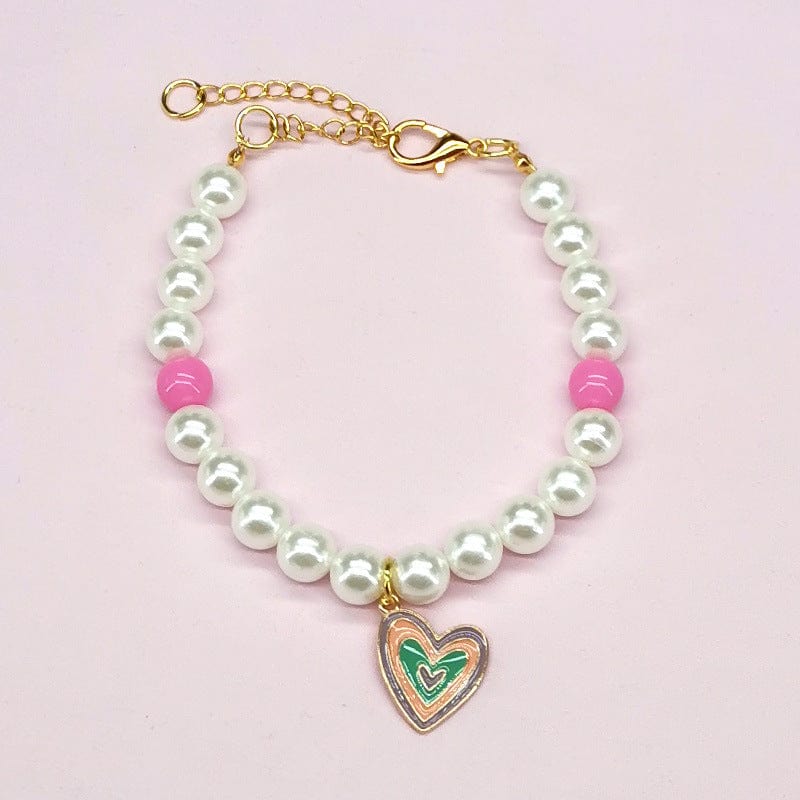 Collier en perles blanches et roses avec un pendentif en cœur, élégant et coloré pour un look tendance.