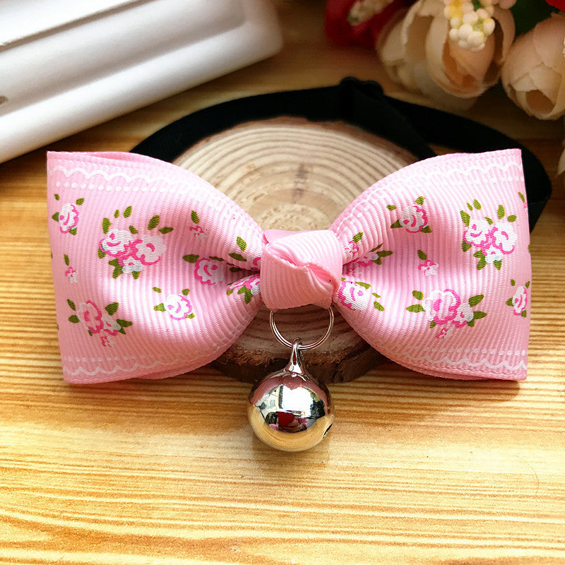 Nœud papillon rose à fleurs avec cloche pour chien et chat, accessoire élégant pour animaux de compagnie.