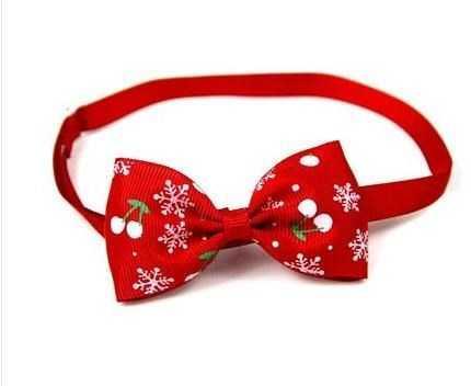 Nœud papillon rouge avec motifs de flocons de neige et cerises, idéal pour les animaux durant les fêtes.
