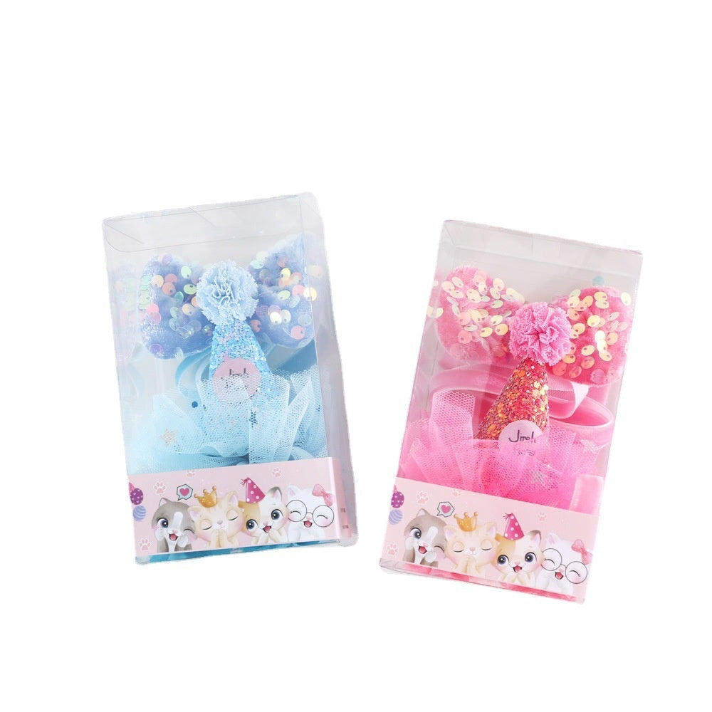 Ensemble d'anniversaire pour chat avec chapeau bleu et rose, nœud papillon et accessoires dans un emballage transparent.
