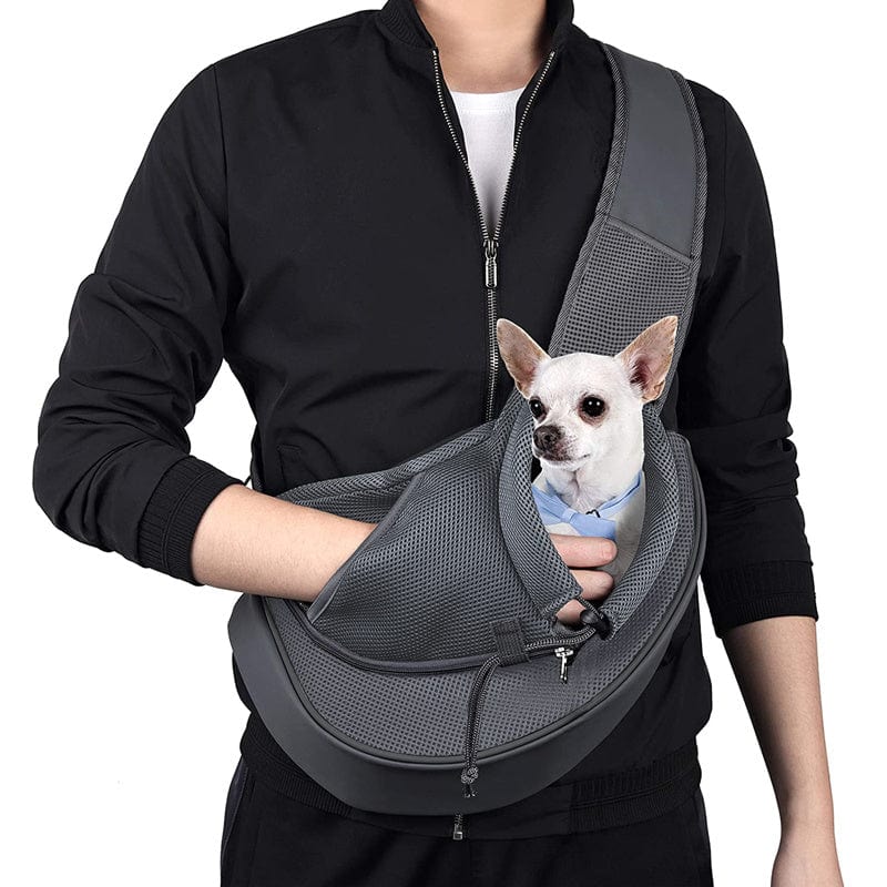Homme portant un sac à bandoulière pour chiots avec un petit chien à l'intérieur, idéal pour le confort et la mobilité.