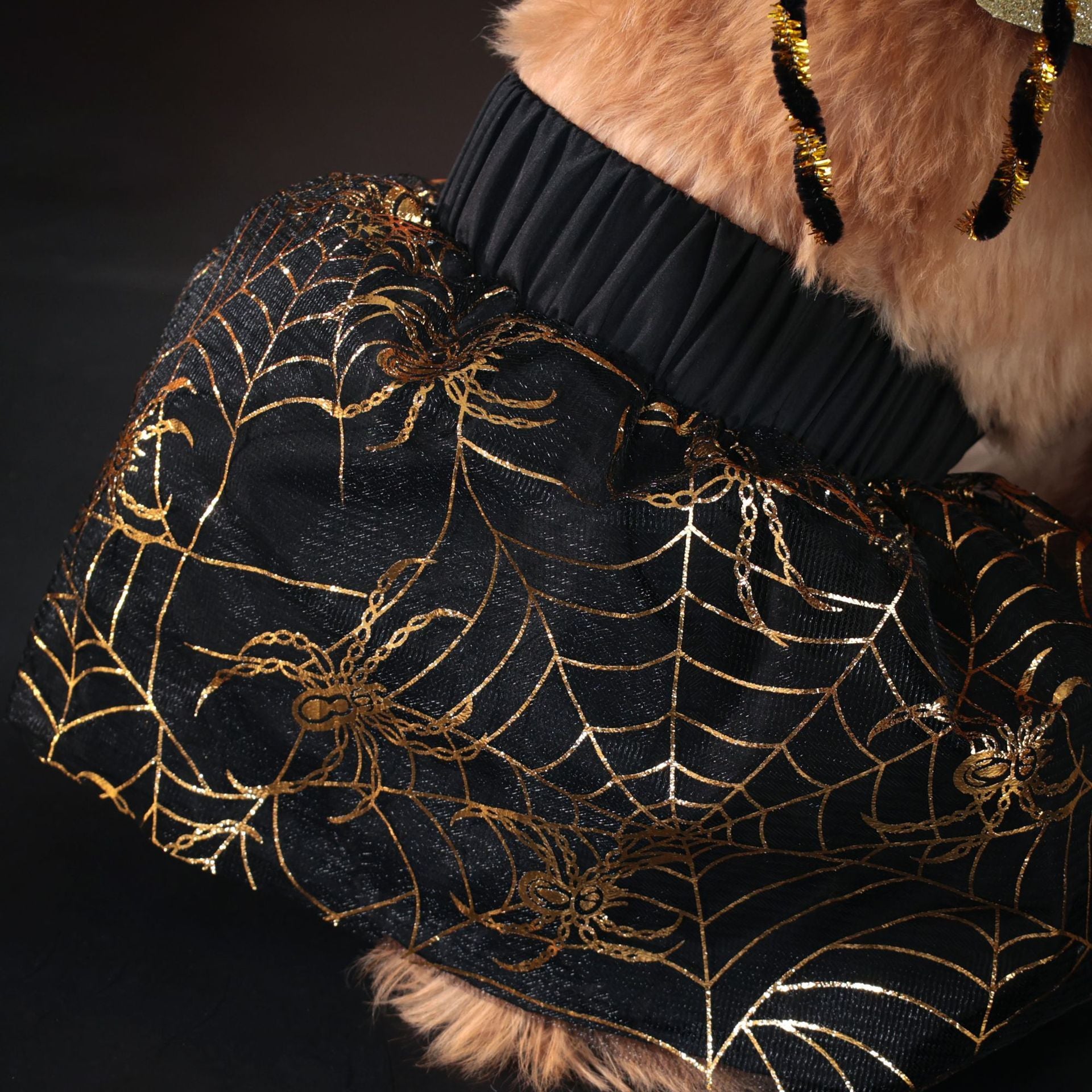 Costume d'Halloween pour chien avec jupette noire à motifs araignées dorées, parfait pour les célébrations festives.