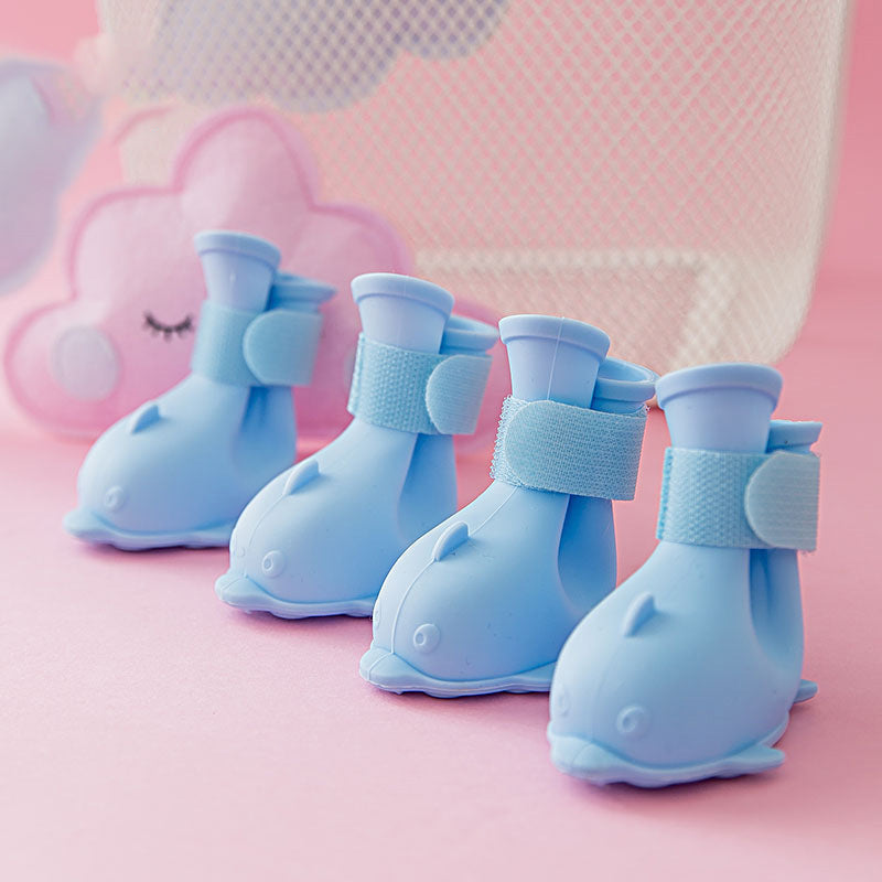 Quatre bottes de pluie pour animaux en gel bleu, enveloppées de velcro, sur fond rose.