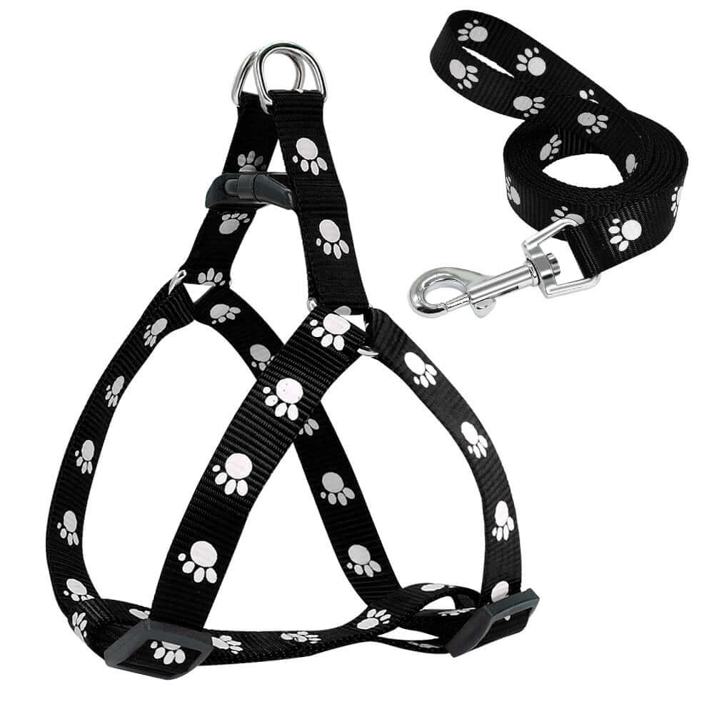 Laisse pour chien imprimée avec harnais ajustable et motifs de pattes blanches sur fond noir.