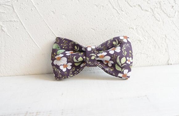 Noeud papillon floral en tissu violet, parfait pour accessoiriser les vêtements d'animaux ou pour des occasions spéciales.