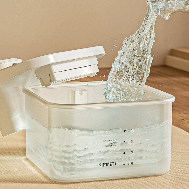 Distributeur d'eau automatique pour chat, montrant l'eau en train d'être versée dans le réservoir transparent.