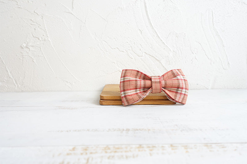 Nœud papillon en tissu à carreaux sur une surface en bois, élégant et stylé pour accessoires chien.