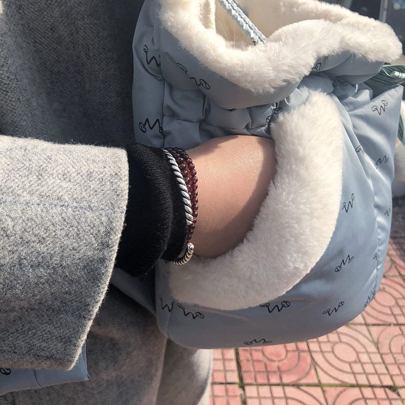 Person holding a light blue animal transport backpack with a plush lining, perfect for winter adventures.