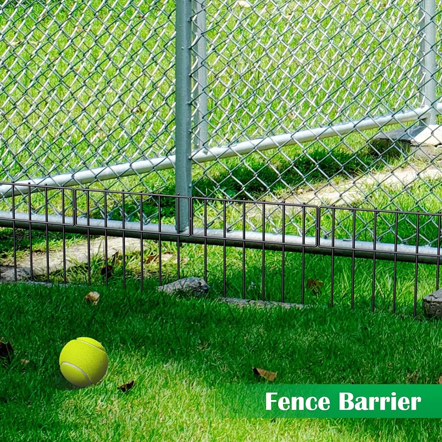 Clôture anti-animal en métal pour jardin avec barrière, protégée par des grilles, et balle de tennis sur l'herbe.
