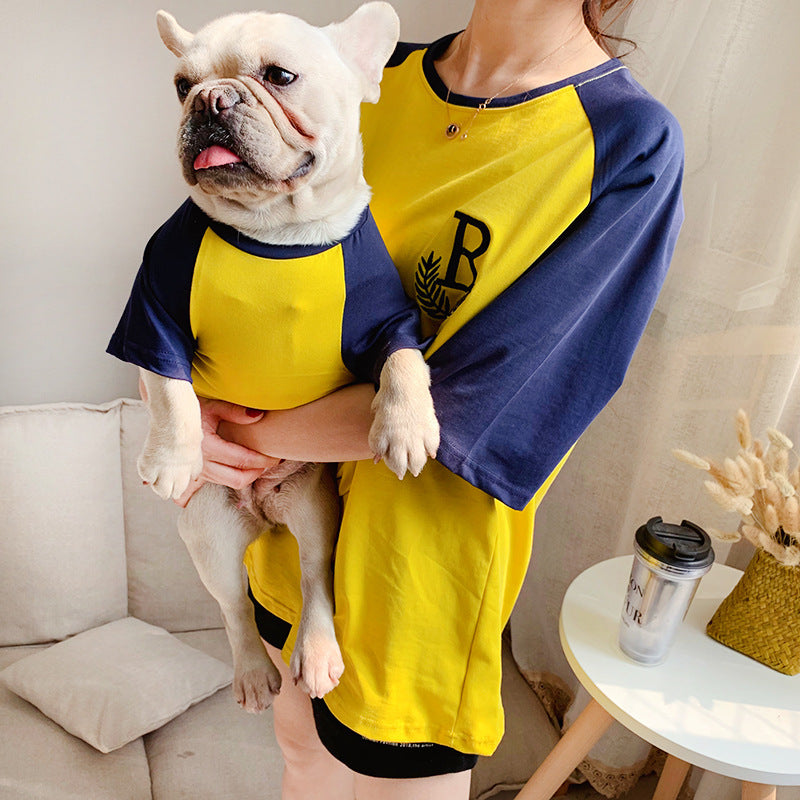 Vêtements assortis parent-enfant avec chien en tee-shirt jaune et bleu, parfaits pour des sorties décontractées.