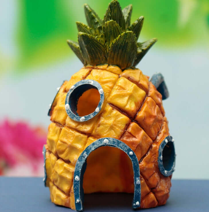 Maison Ananas pour poissons d'aquarium, décoration aquatique en résine, créant un écosystème coloré.