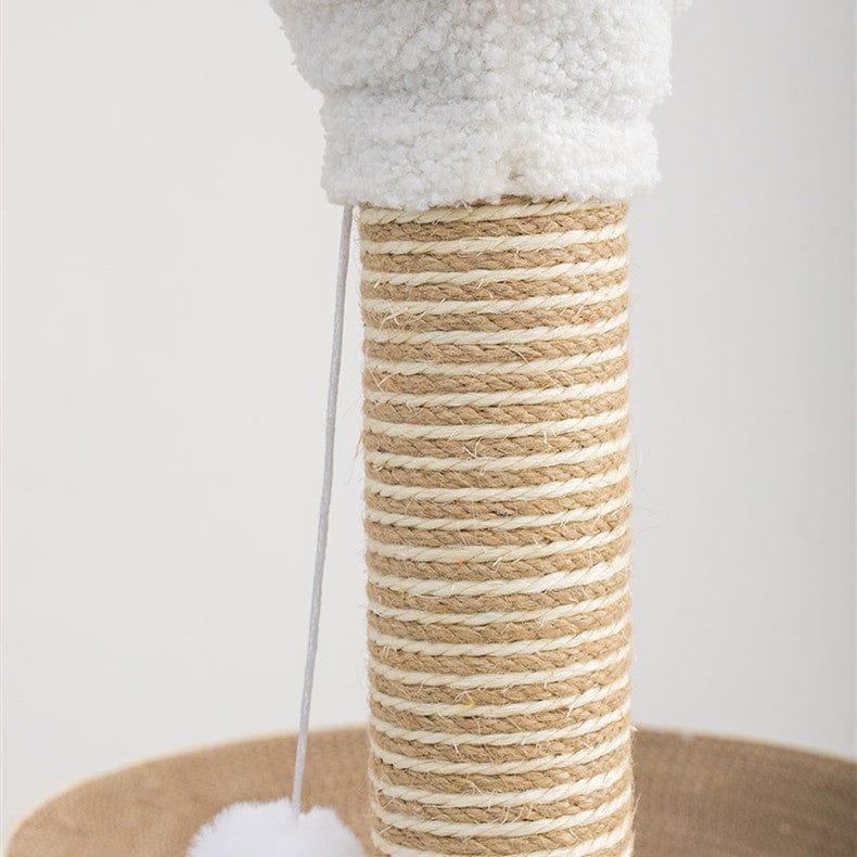 Détail de la plaque à gratter ronde en carton pour chat, avec poteau en sisal et jouet en peluche.