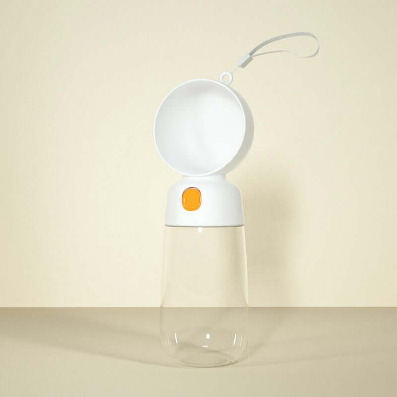 Gourde portable pour chien blanche avec capuchon orange, idéale pour l'hydratation lors des sorties avec votre animal.
