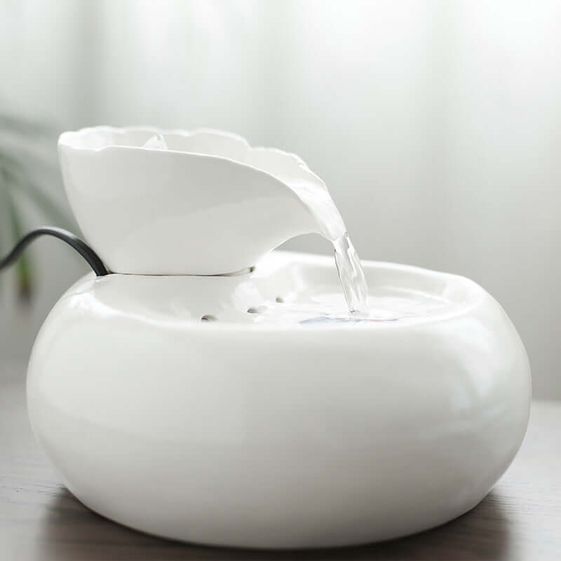Distributeur d'eau automatique en porcelaine blanche pour chat, design élégant et moderne, offrant un accès constant à l'eau fraîche.