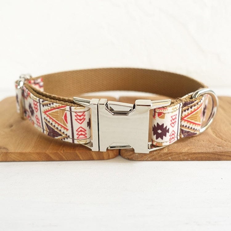 Collier pour chien Boho Chic en polyester avec motif coloré et boucle en métal, sur un support en bois.