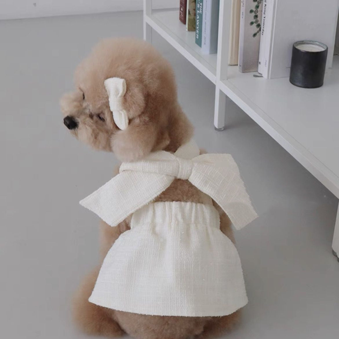 Chien en jupe sling blanche avec noeud, vêtement stylé pour animaux en tissu doux, parfait pour toutes occasions.