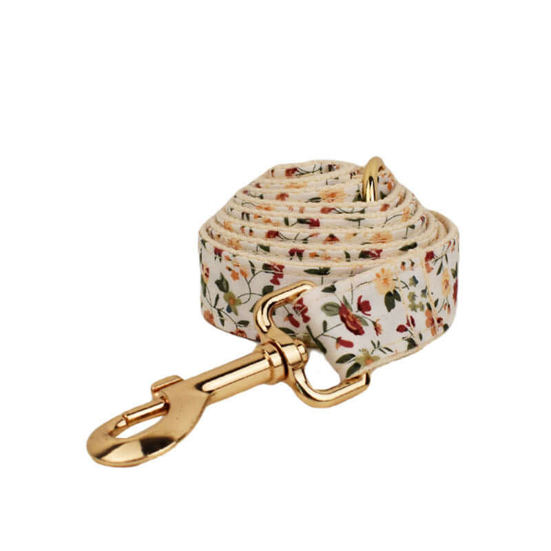Laisse pour chien en tissu floral avec clip doré, design élégant et pratique pour promenades.
