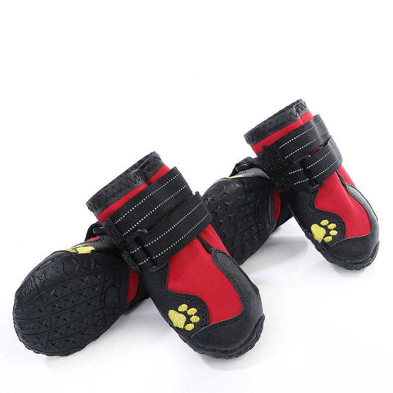 Bottes pour chien imperméables en caoutchouc rouge avec semelles antidérapantes et sangles de maintien.