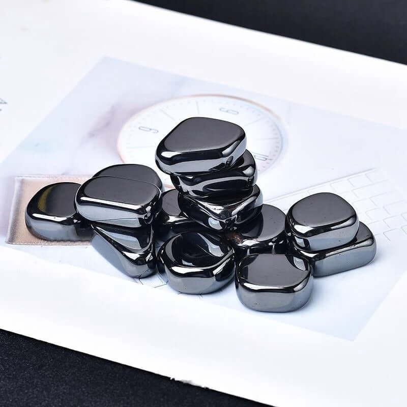 Ornements en pierre brute d'hématite brésilienne naturelle, pièces noires brillantes sur fond neutre.