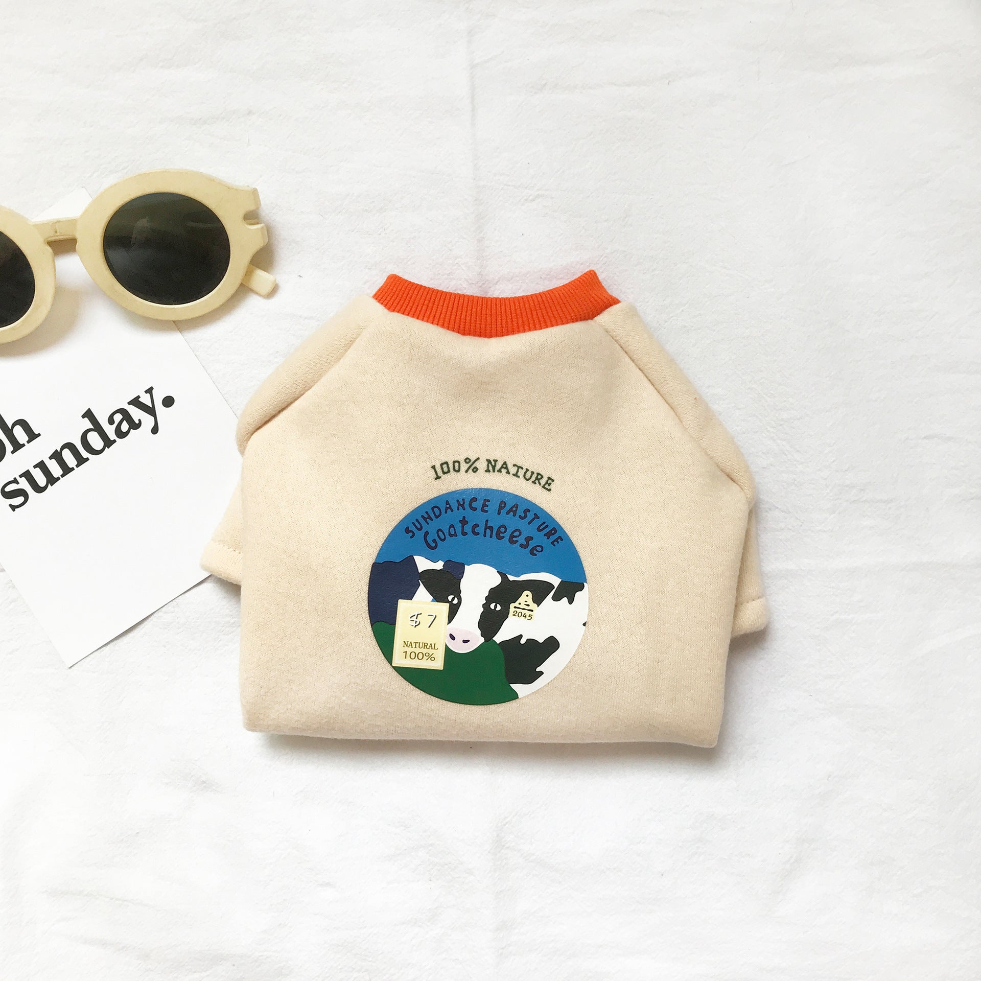 Pull beige pour chats avec design vache, textile en coton biologique, idéal pour saisons fraîches.
