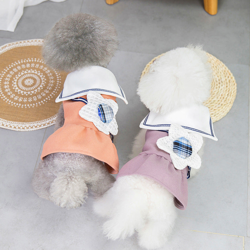 Deux chiens portant des jupes à fleurs colorées avec col blanc, offrant un look élégant et confortable.