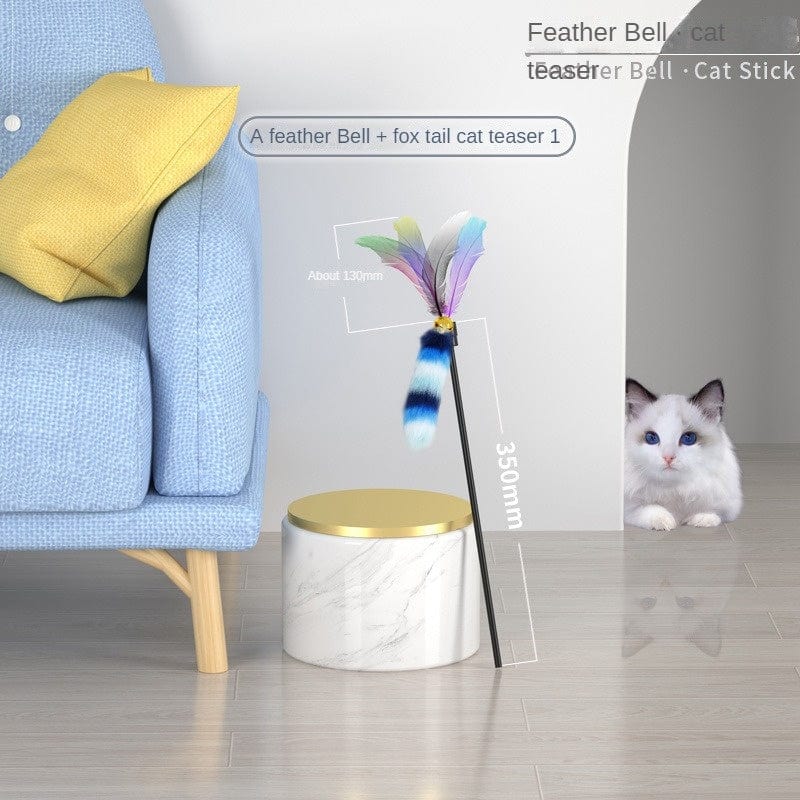 Feather Bell cat teaser stick with colorful feathers near a couch and a curious cat peeking from behind.