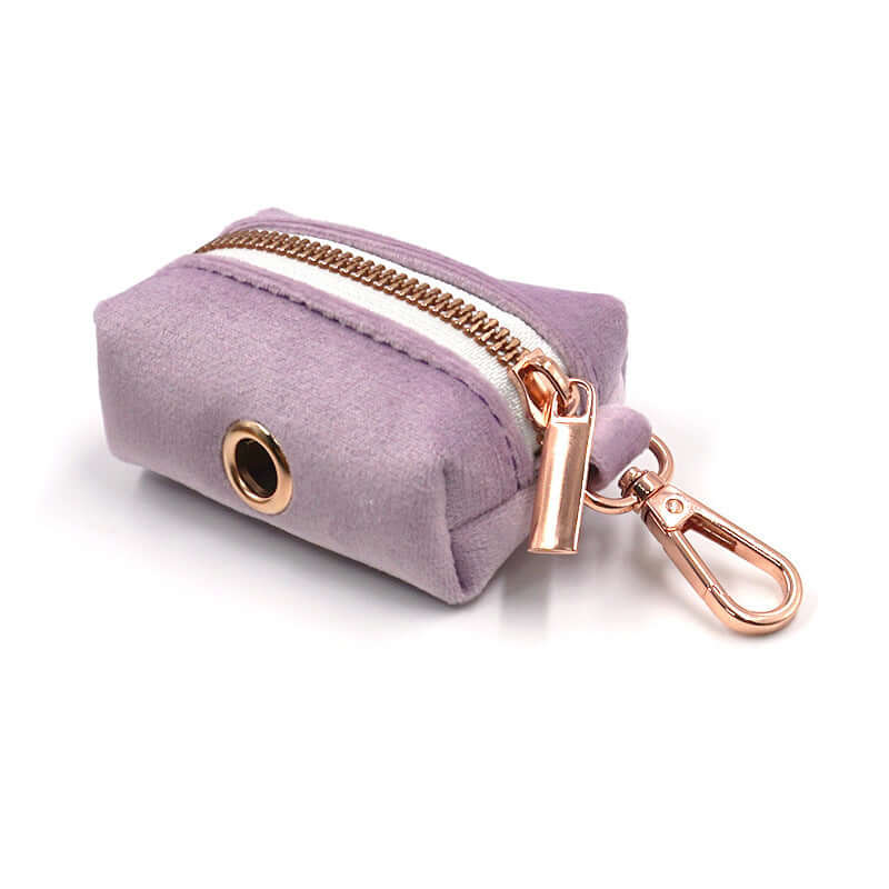 Petit sac en velours lavande avec fermeture éclair et attache dorée, parfait pour les accessoires.