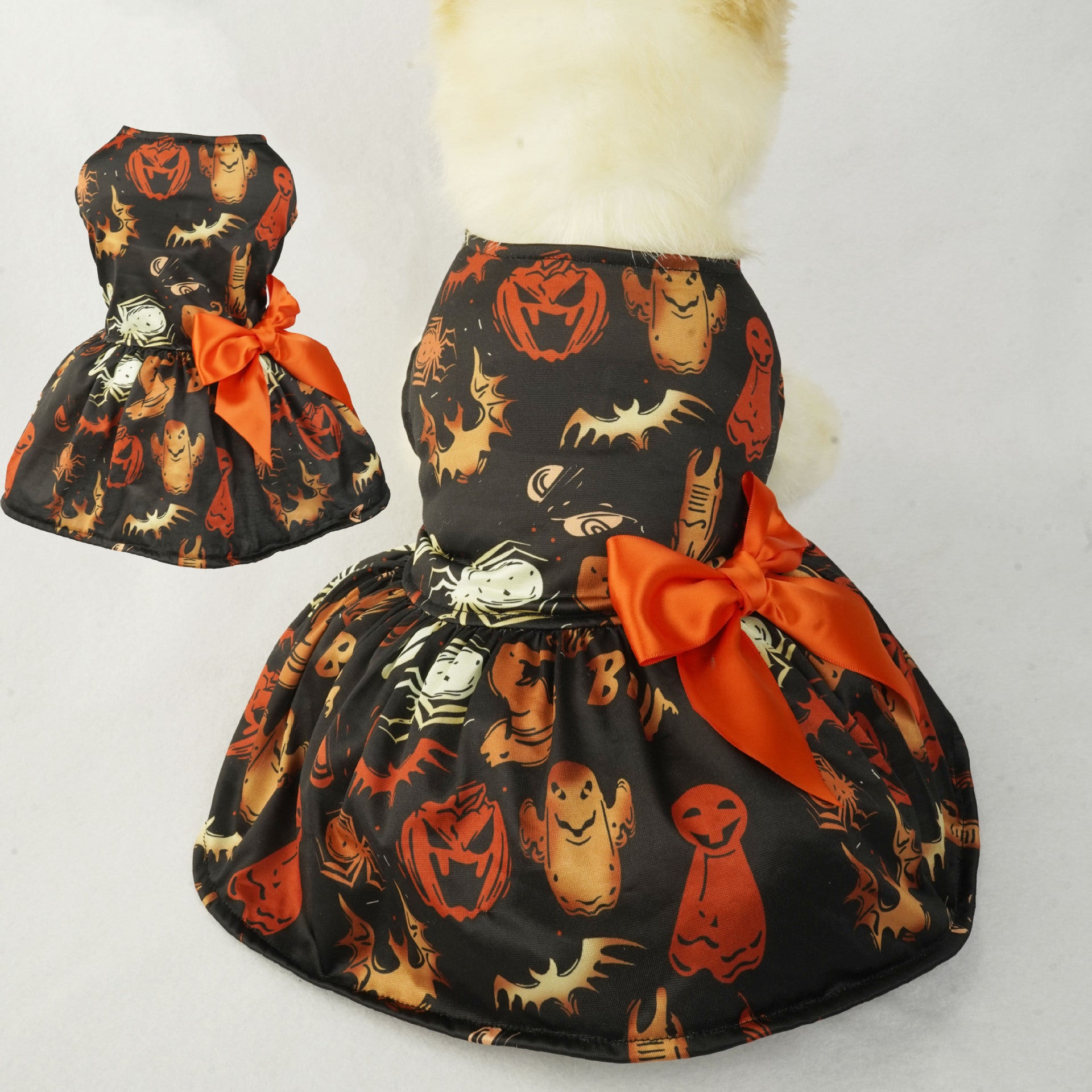 Robe d'Halloween pour petit chien avec imprimé citrouille et un nœud orange, idéale pour fêter Halloween.