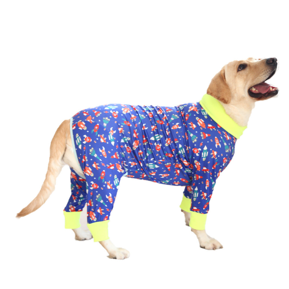 Chien heureux portant un pyjama en coton bleu avec motifs colorés et col vert fluo, alliant confort et style.