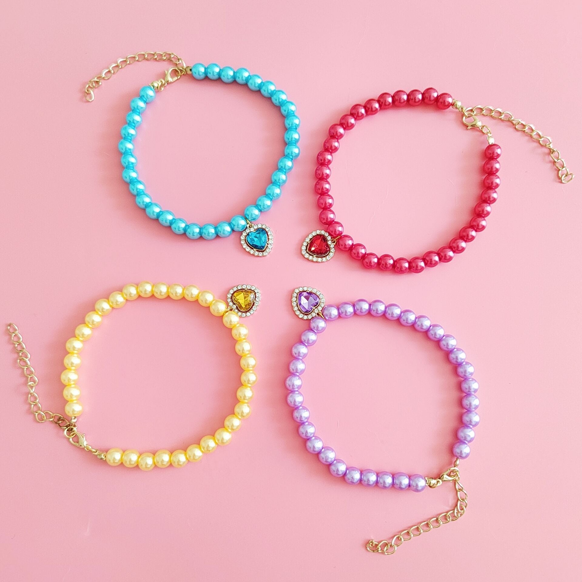 Collier pour chat en perles colorées avec pendentifs, disponible en violet, rouge, bleu et jaune.