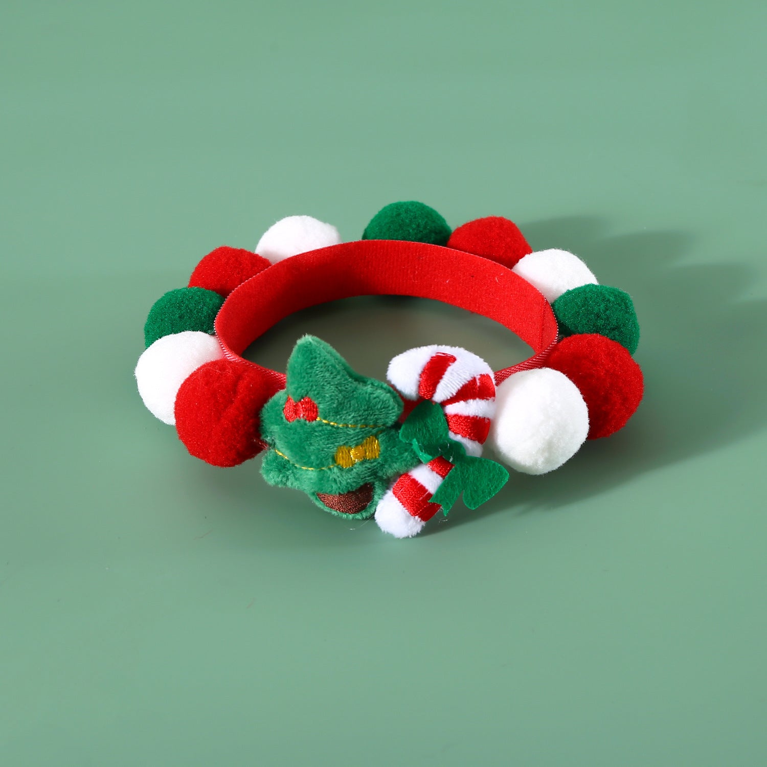 Collier en peluche Noël pour animaux avec pompons colorés rouge, blanc et vert, décoré d'un sapin et bonbons.
