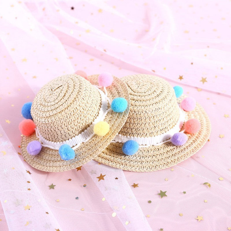 Chapeaux en papier beige avec pompons colorés, parfaits pour chiens et chats, sur fond rose brillant.