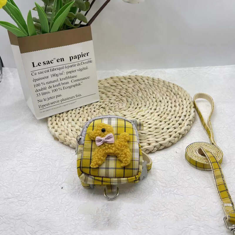 Sac à dos pour animaux en motif à carreaux jaunes avec harnais et corde de traction sur une table.