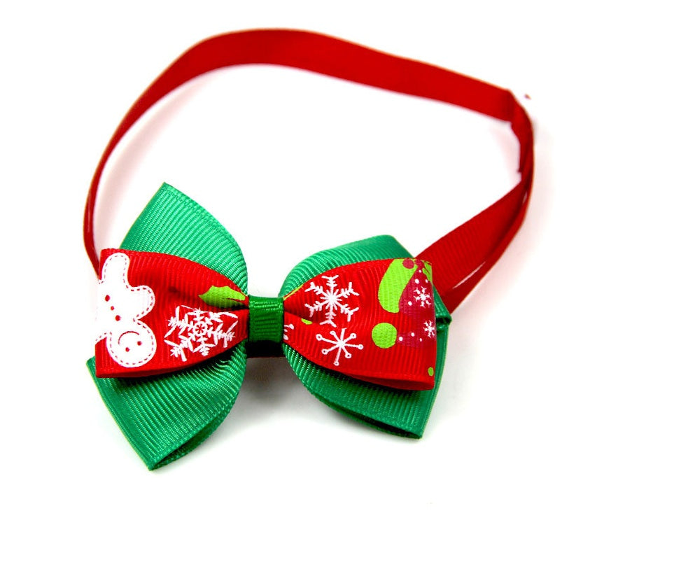 Nœud papillon de Noël festif pour animaux de compagnie, coloré en rouge et vert avec motifs de flocons et bonhomme de neige.
