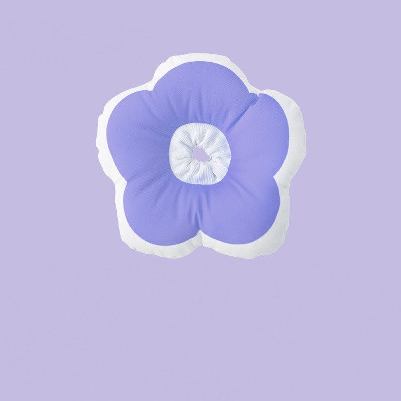 Coussin en forme de fleur violet avec contours blancs sur fond violet, idéal pour animaux de compagnie.