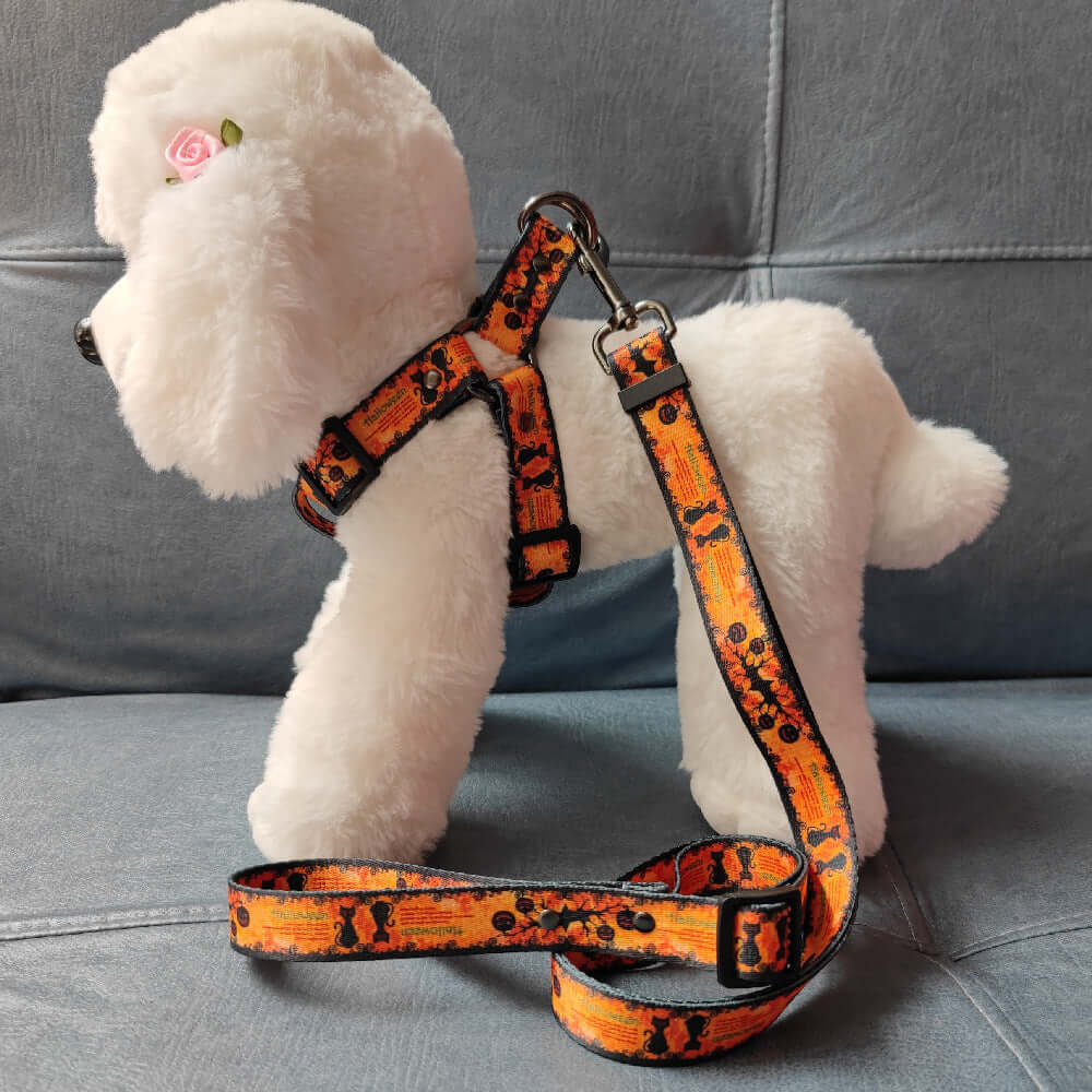 Harnais et laisse à imprimé citrouille Halloween sur un chien en peluche pour un look tendance.