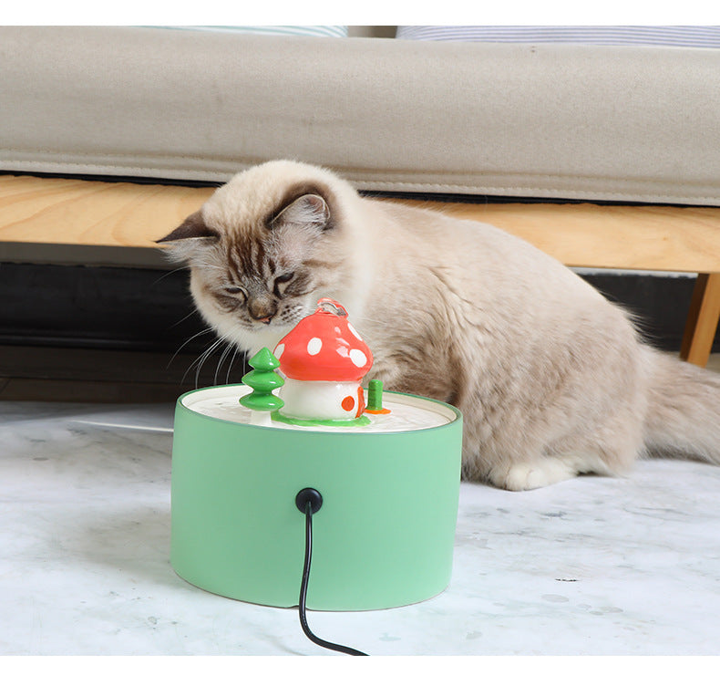 Chat curieux explorant une fontaine à eau électrique en céramique avec un design amusant.