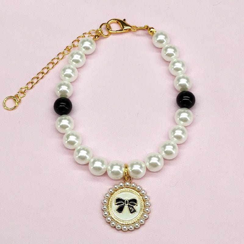 Collier élégant en perles blanches et noires avec pendentif à nœud pour animaux, accessoire festif.