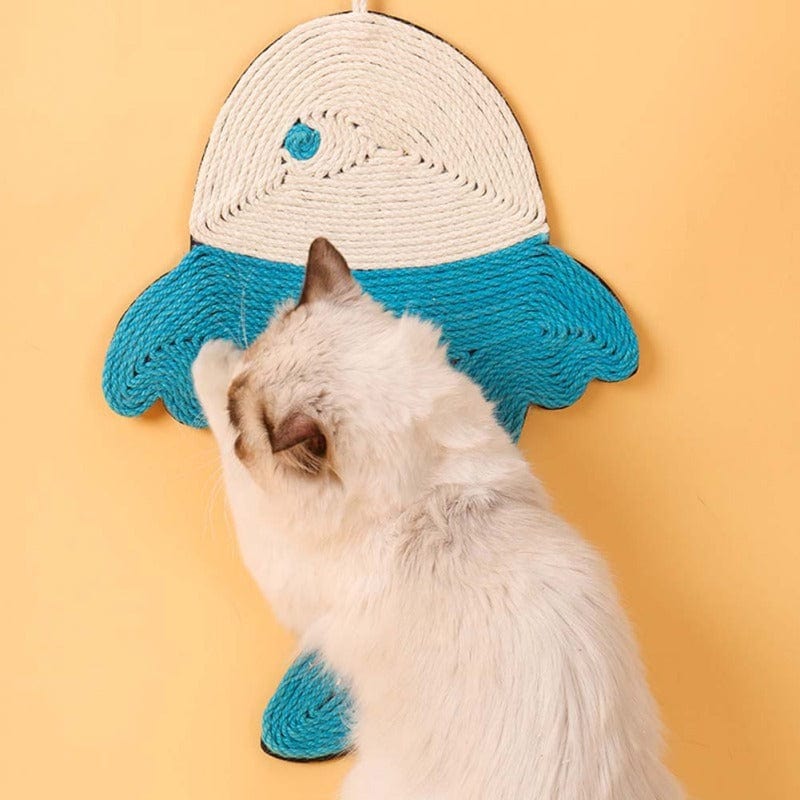 Chat jouant avec un tapis à gratter en forme de poisson, parfait pour garder ses griffes en bonne santé.