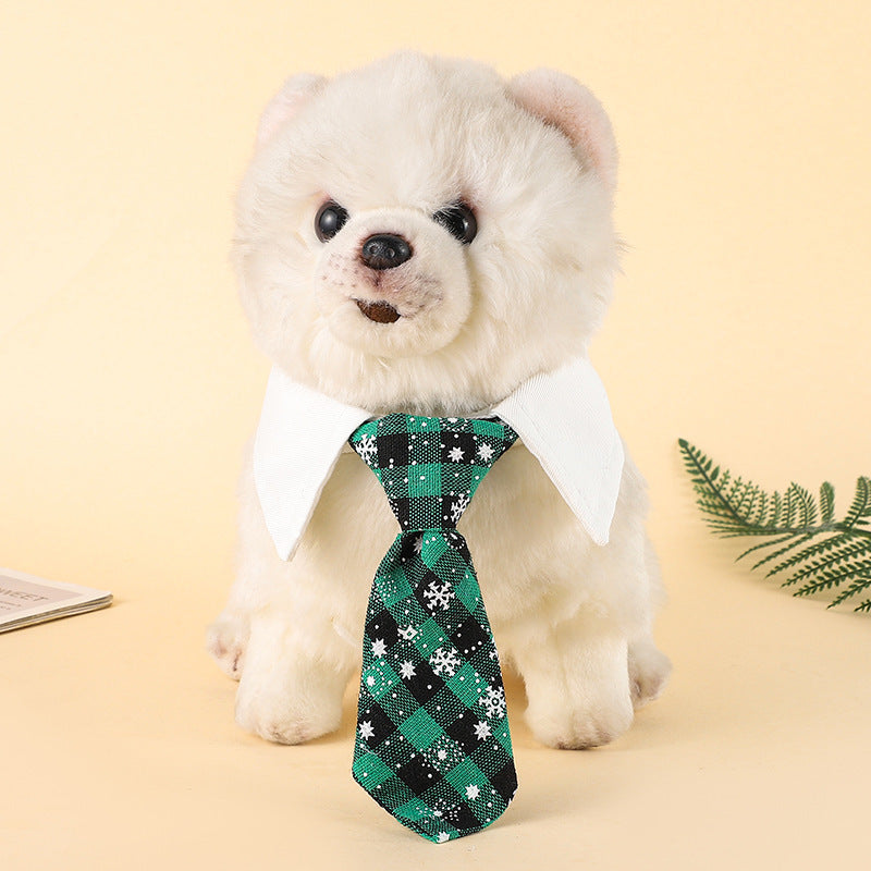 Chien en peluche portant une cravate à motif tartan vert et blanc, élégant accessoire pour Noël.