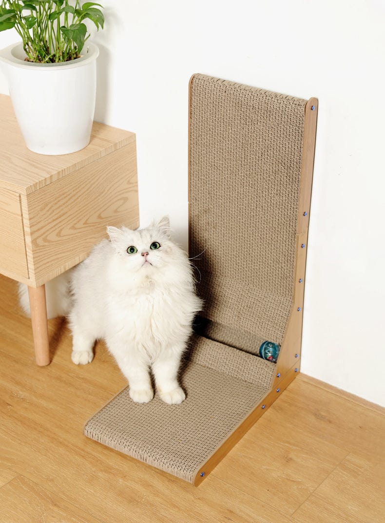 Griffoir vertical L pour chats en carton ondulé avec un chat blanc curieux à côté, idéal pour le bien-être félin.